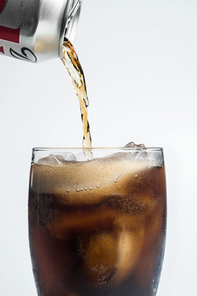 Studio photograph of a Diet Coke pouring into a glass