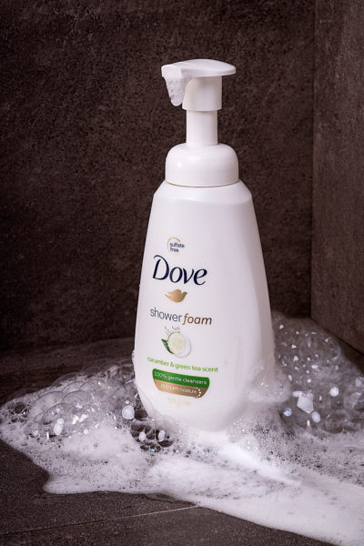Dove Shower Foam Body Wash surrounded by soapy bubbles