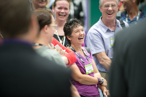 Attendees laughing in a Veterinary Convention exhibit hall