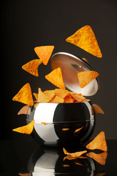 Frozen action photograph of Doritos exploding out of a shiny ice bucket