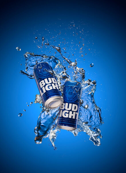 Two Bud Light Cans being splashed by water